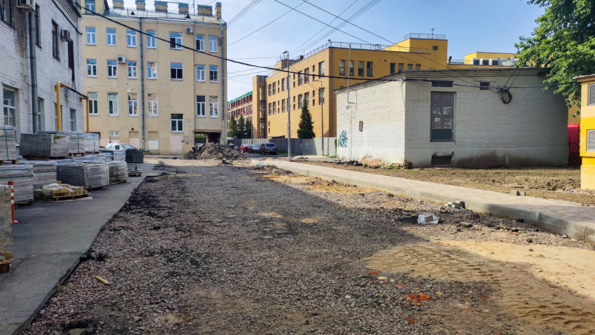 Дворовая стройплощадка с основанием дороги из щебня и штабелями материалов