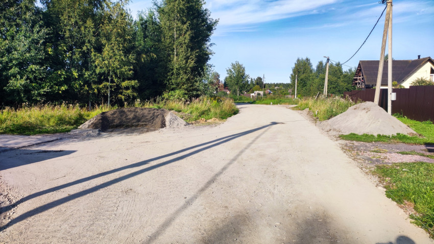 Выравненная улица в посёлке с отсыпкой инертным материалом и насыпями у обочин