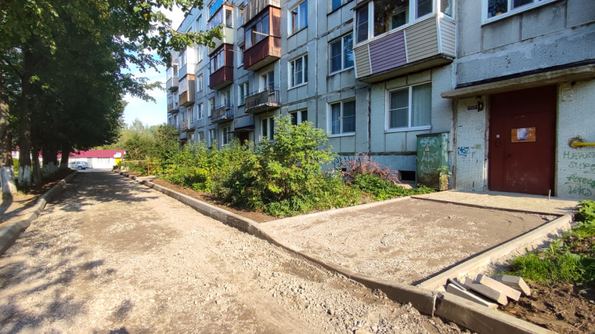 У подъезда сделали площадку в бордюрах и отсыпали проезд щебнем вдоль панельного дома