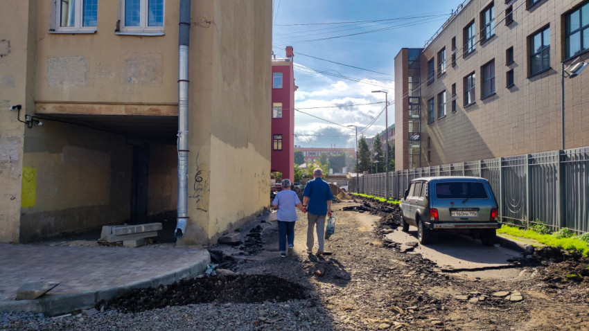 Разрушенное дорожное покрытие на улице во время ремонта и пешеходы