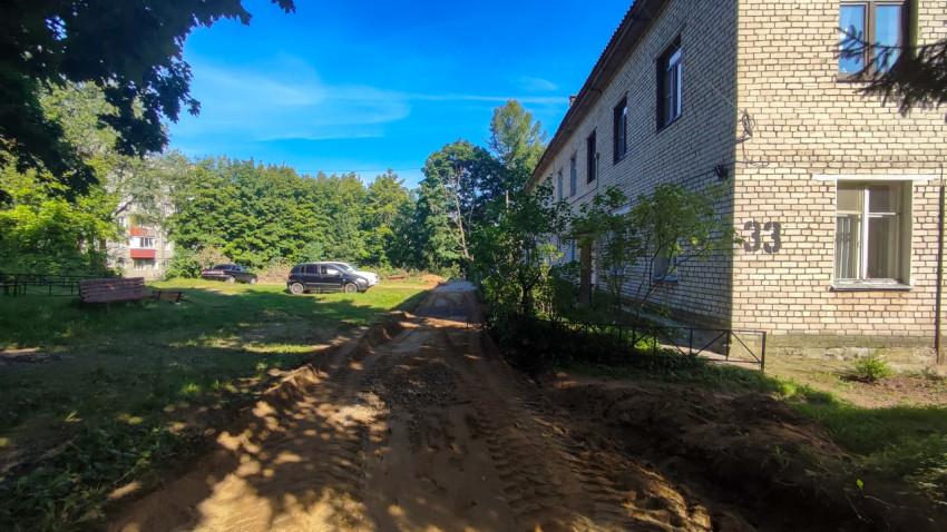 Грунтовый проезд с колеями у жилого дома во время ремонта