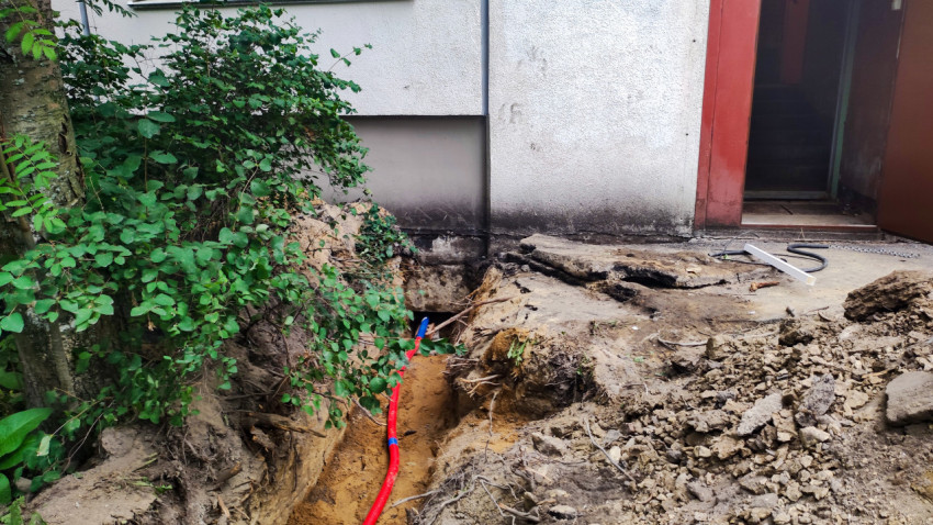 Траншея с уложенными коммуникациями и песчаной подсыпкой у тротуара