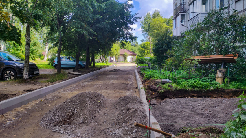 Линия бордюров и щебёночное основание на дворовой дорожке у жилой застройки