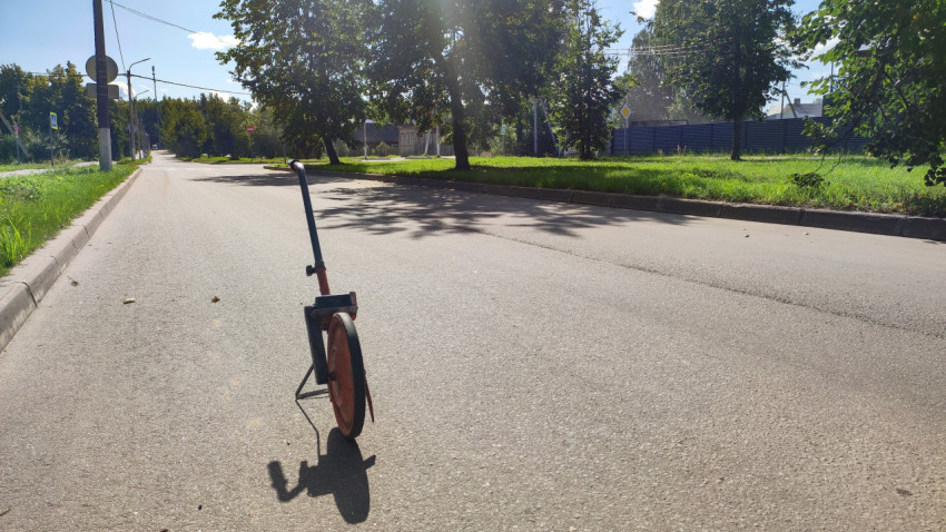 Крупный план измерительного колеса на асфальте, готового к дорожным замерам