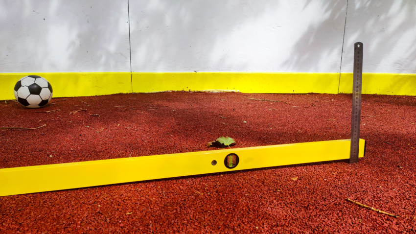 Измерение ровности покрытия рядом с футбольным мячом у борта площадки