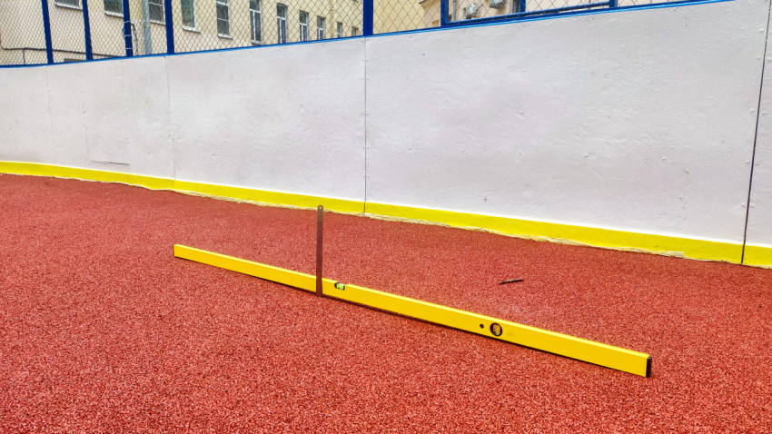 Измерительный уровень и линейка на резиновом покрытии у ограждения