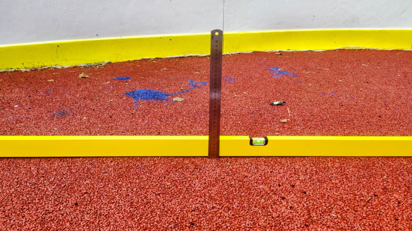 Проверка ровности резинового покрытия строительным уровнем и линейкой