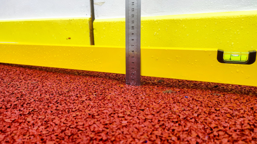 Макросъёмка линейки и уровня при измерении зазора на мокром резиновом покрытии