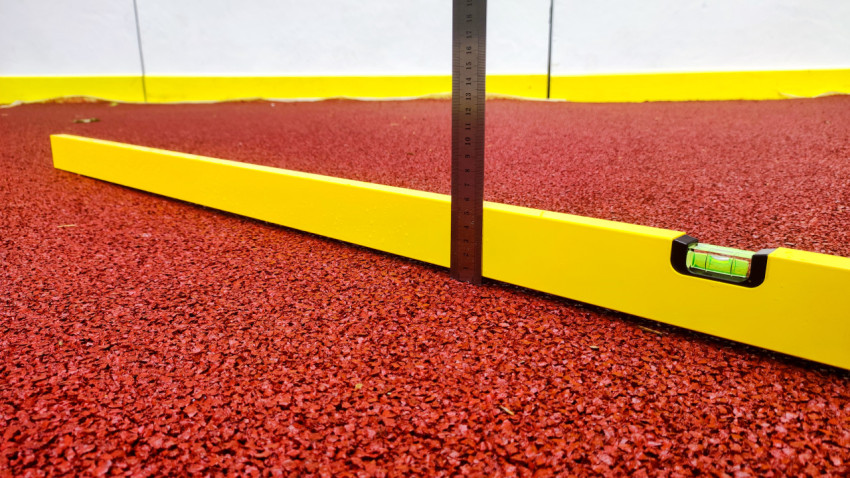 Контроль перепада резинового покрытия линейкой по строительному уровню