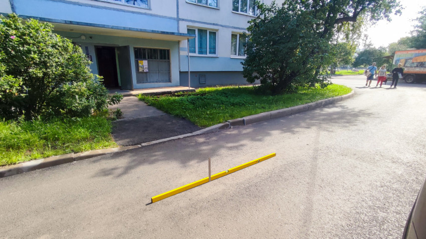 Длинный строительный уровень и измерительная рейка на асфальте для проверки ровности покрытия