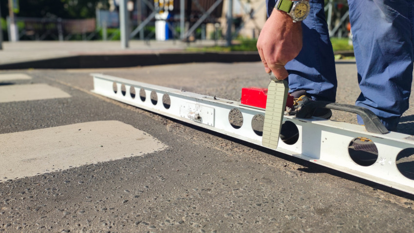 Снимают просвет под рейкой клин-промерником, проверяя ровность асфальта