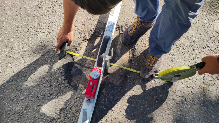 Измеряют ширину и глубину дефекта на дороге: рулетка, рейка и фотофиксация на месте