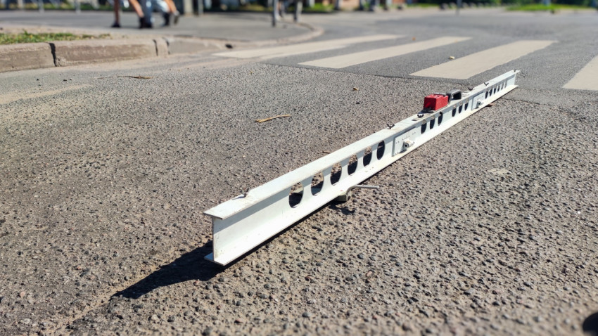 Рейка для замера ровности лежит на асфальте у «зебры», всё готово к промеру