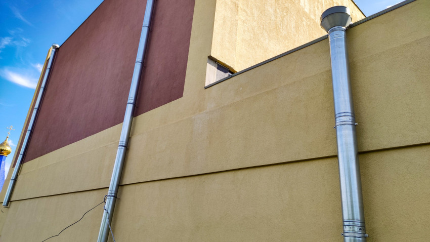 Фасад здания с оцинкованным водостоком и контрастной отделкой