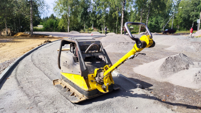 Виброплита для уплотнения основания на участке дорожных работ у бордюра