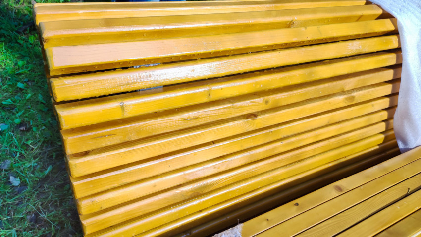 Текстура мокрой деревянной спинки скамейки с каплями воды и древесными сучками