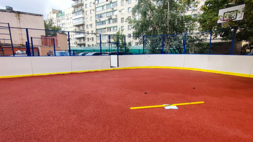 Строительный уровень на резиновом покрытии спортивной площадки во дворе