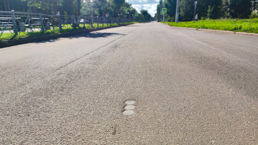 Текстура асфальта на переднем плане с размытым фоном городской улицы