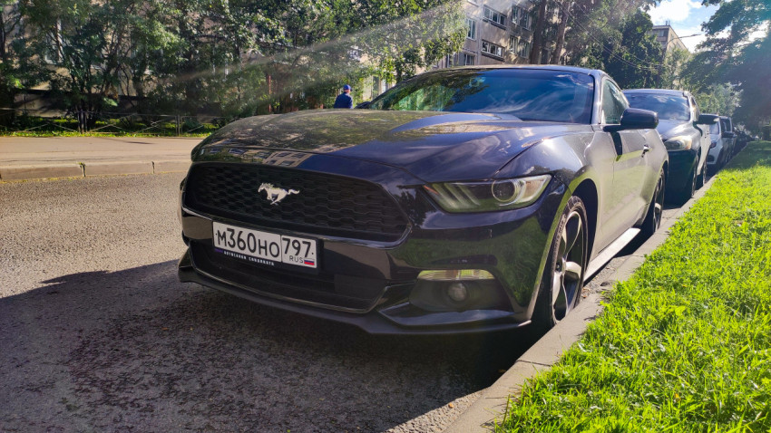 Ford Mustang у обочины рядом с газоном и рядом припаркованных автомобилей