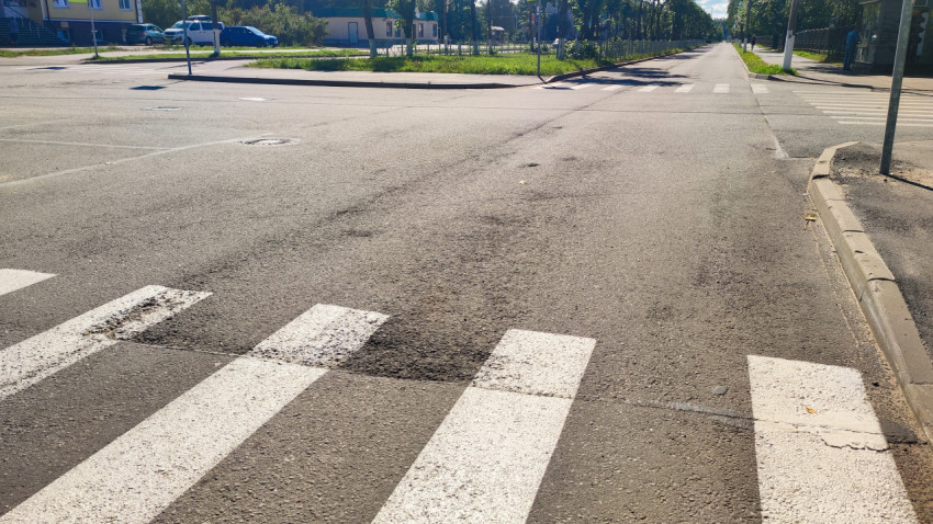 Разметка пешеходного перехода на асфальте у края проезжей части и тротуара