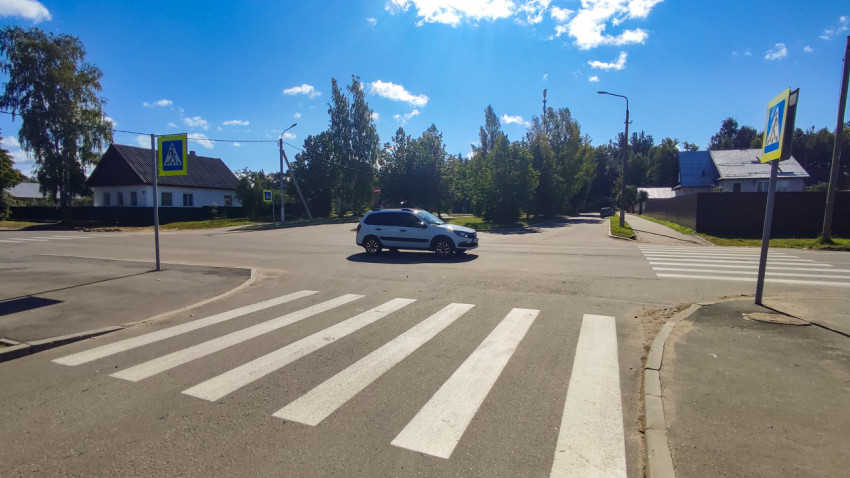 Зебра на перекрёстке и белый кроссовер, поворачивающий через пешеходный переход