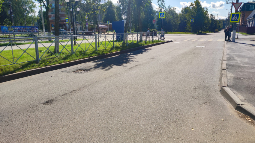 Перекрёсток с дорожными знаками и ограждением у пешеходного перехода