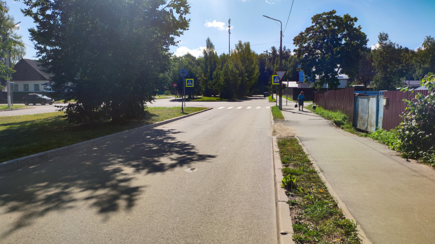 Тихий перекрёсток с пешеходным переходом, тротуаром и тенями от деревьев