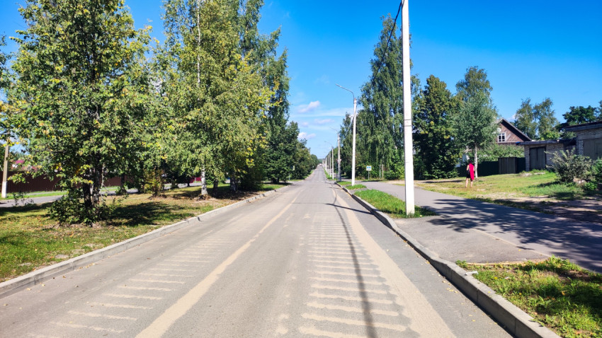 Дворовая улица с асфальтом и тротуаром, снятая вдоль перспективы жилого района