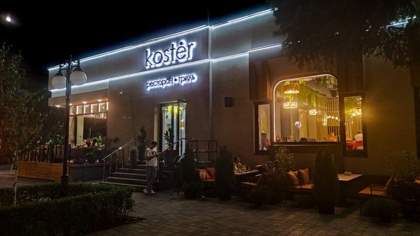 Фасад ресторана koster с вечерней подсветкой и летней террасой