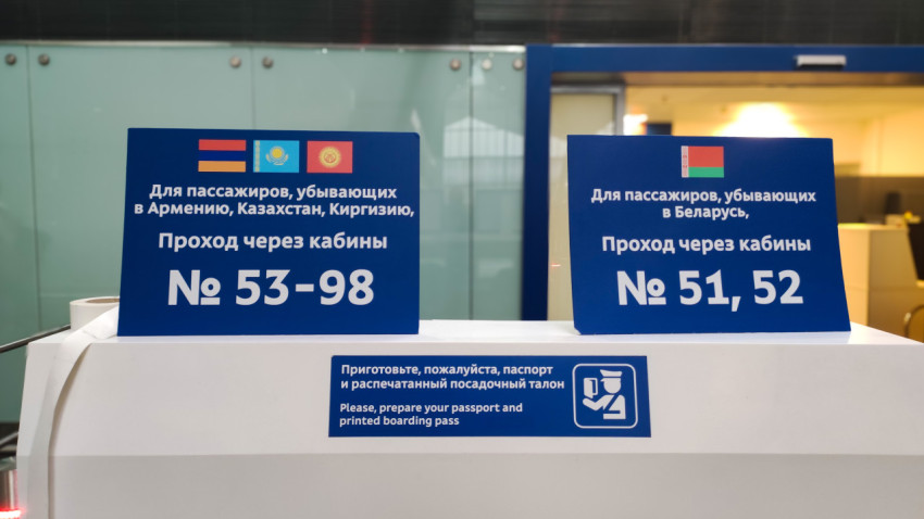 Стойка с напоминанием про паспорт и посадочный, плюс указатели на кабины