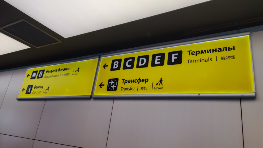 Желтый указатель в терминале: выход, багаж и пересадка на другие терминалы