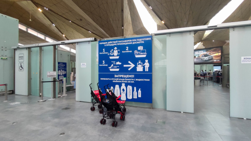 Вход в зону досмотра, стенд с инструкцией и рекламный экран LADA Vesta