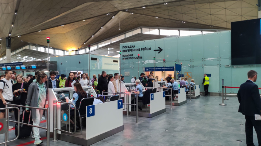 Контрольные стойки с номерами и очередь перед посадкой