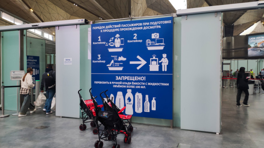 Информационный плакат о досмотре и ряд складных детских колясок