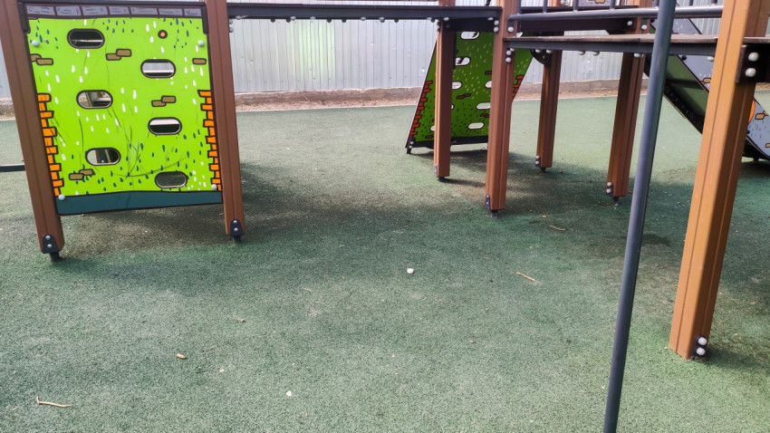 Зелёная панель для лазания и платформа игрового комплекса на площадке