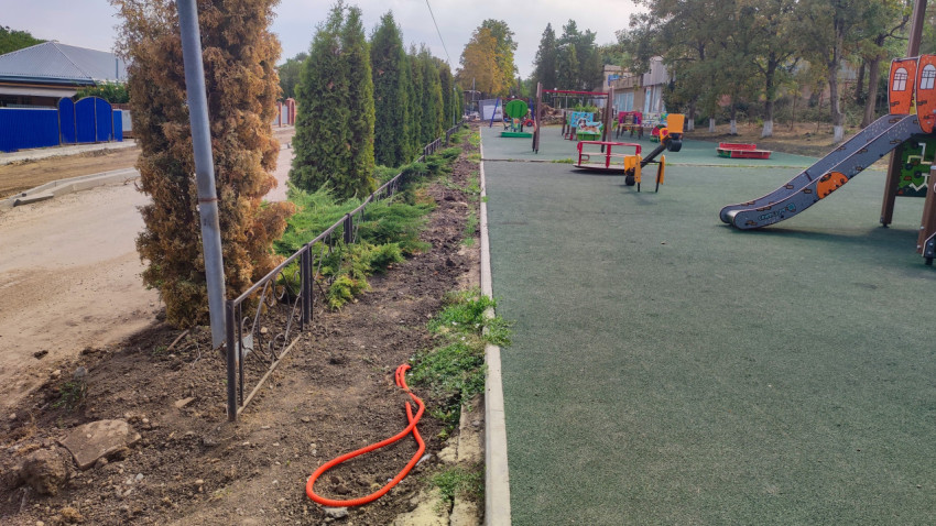 Дворовая дорожка и кромка детской площадки с озеленением и трубой