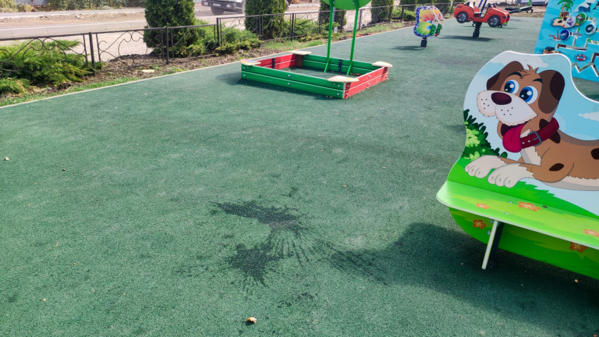 Песочница на резиновом покрытии детской площадки в поселке