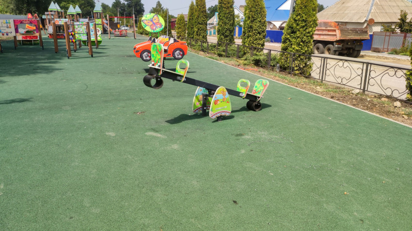 Детская площадка с качалкой и резиновым покрытием во дворе