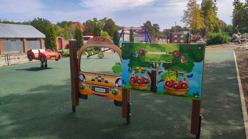 Развивающие стенды «Такси» и яблоня на площадке в поселке