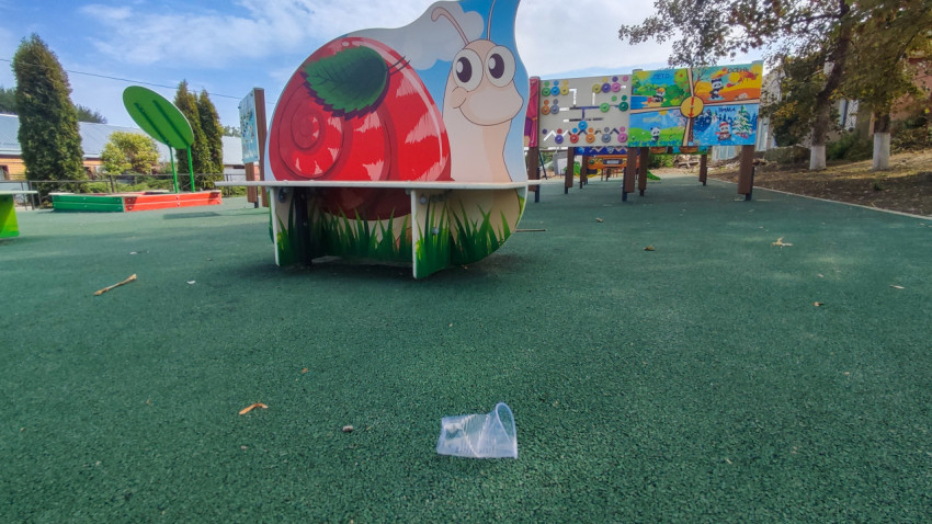 Детская площадка во дворе с игровыми панелями и фигурой улитки