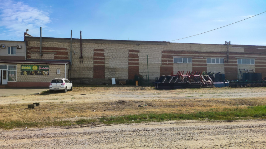 Кирпичный склад у дороги и площадка с сельхознавесным оборудованием