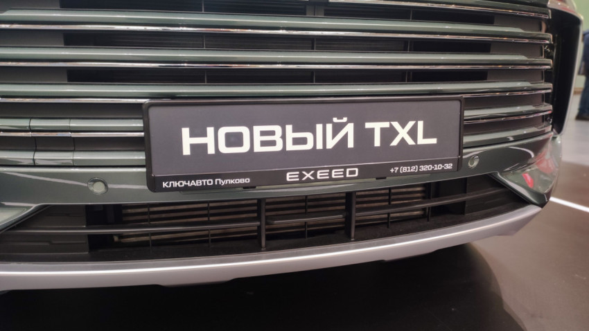 Передняя решётка радиатора и табличка «Новый TXL» крупным планом