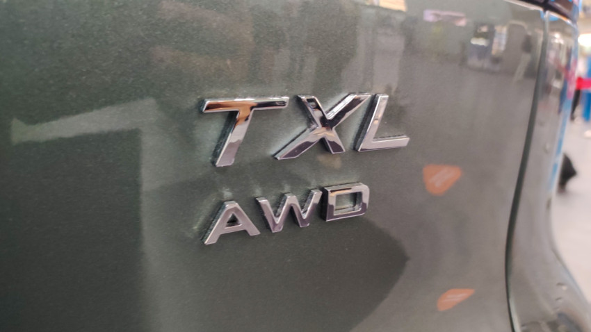Шильдик TXL AWD крупным планом на кузове