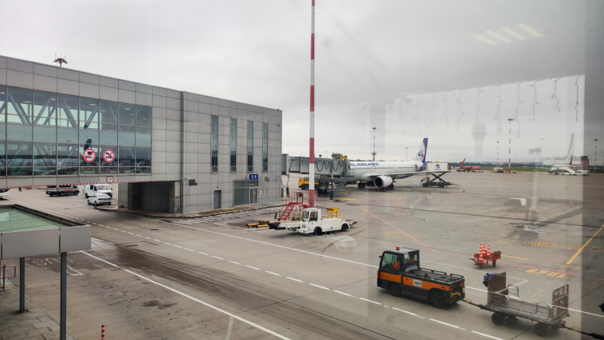 Самолёт Ural Airlines у телетрапа и работа наземной техники на перроне