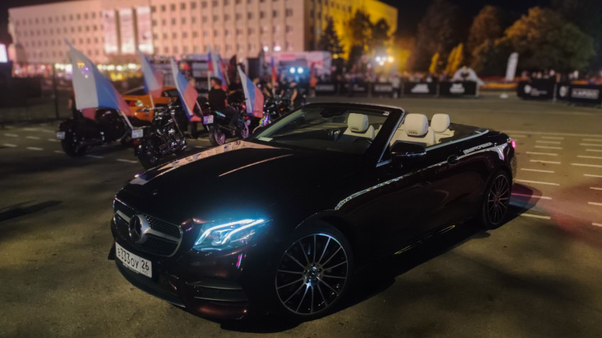 Mercedes-кабриолет и мотоциклы на фоне яркой иллюминации