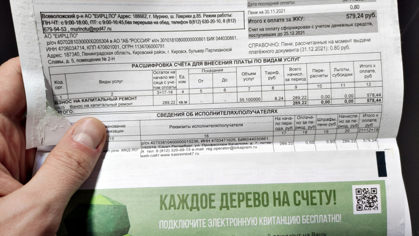Человек держит платежку за капитальный ремонт в руке