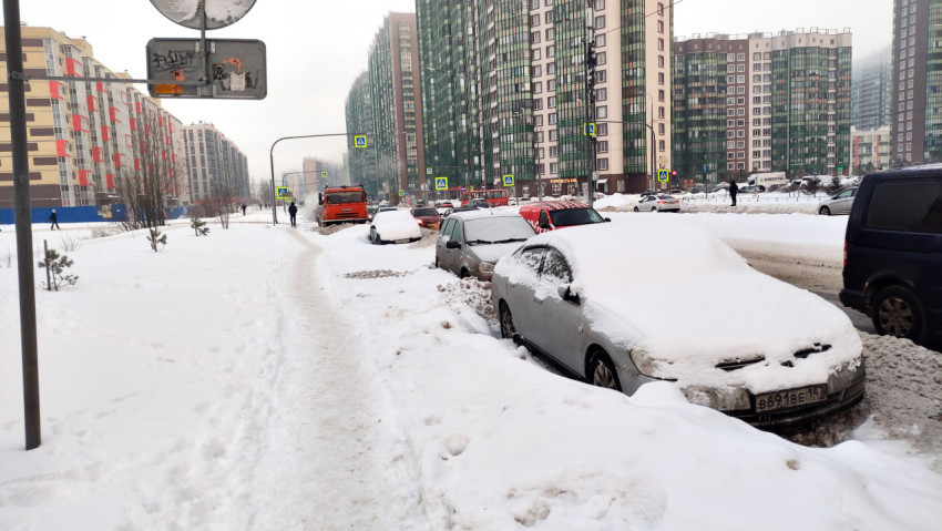 Заснеженная улица с припаркованными автомобилями
