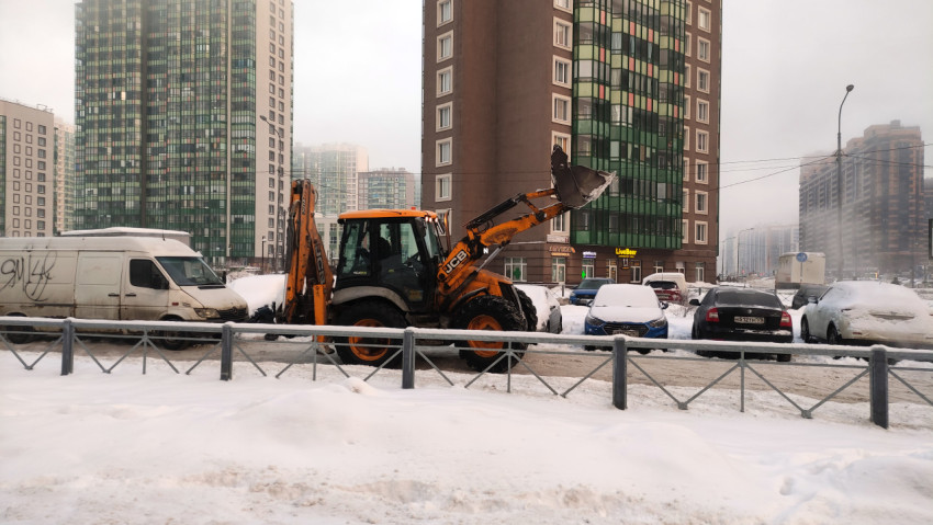 Трактор чистит снег в городе