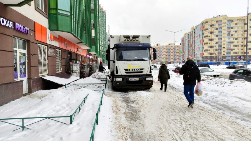 Грузовик припаркован на тротуаре для разгрузки товара в магазин