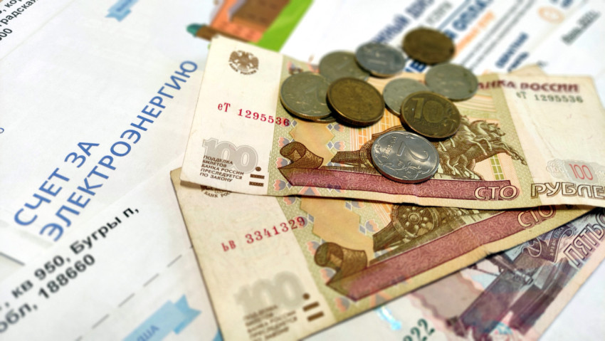 Купюры лежат друг на друге и на квитанциях ЖКУ